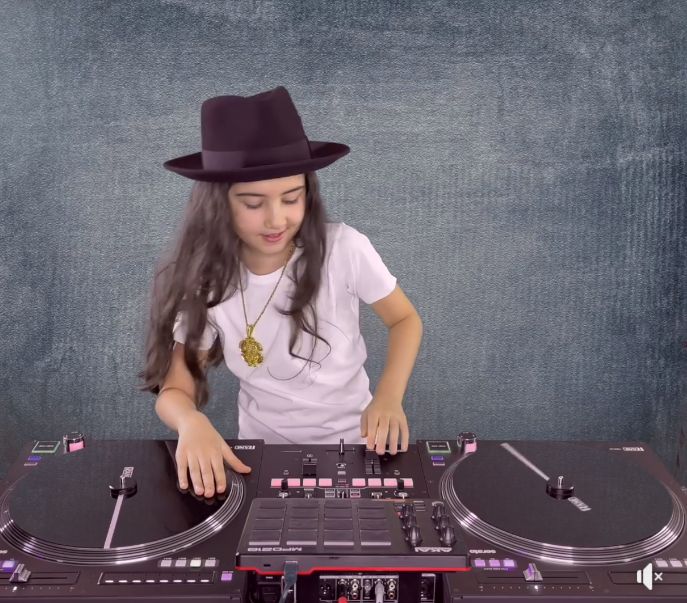 Bé gái học DJ trên bàn DJ turntable